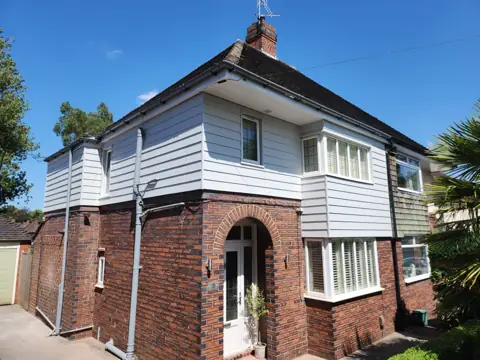 Pale cladding on a brick house — CG Cladding Solutions